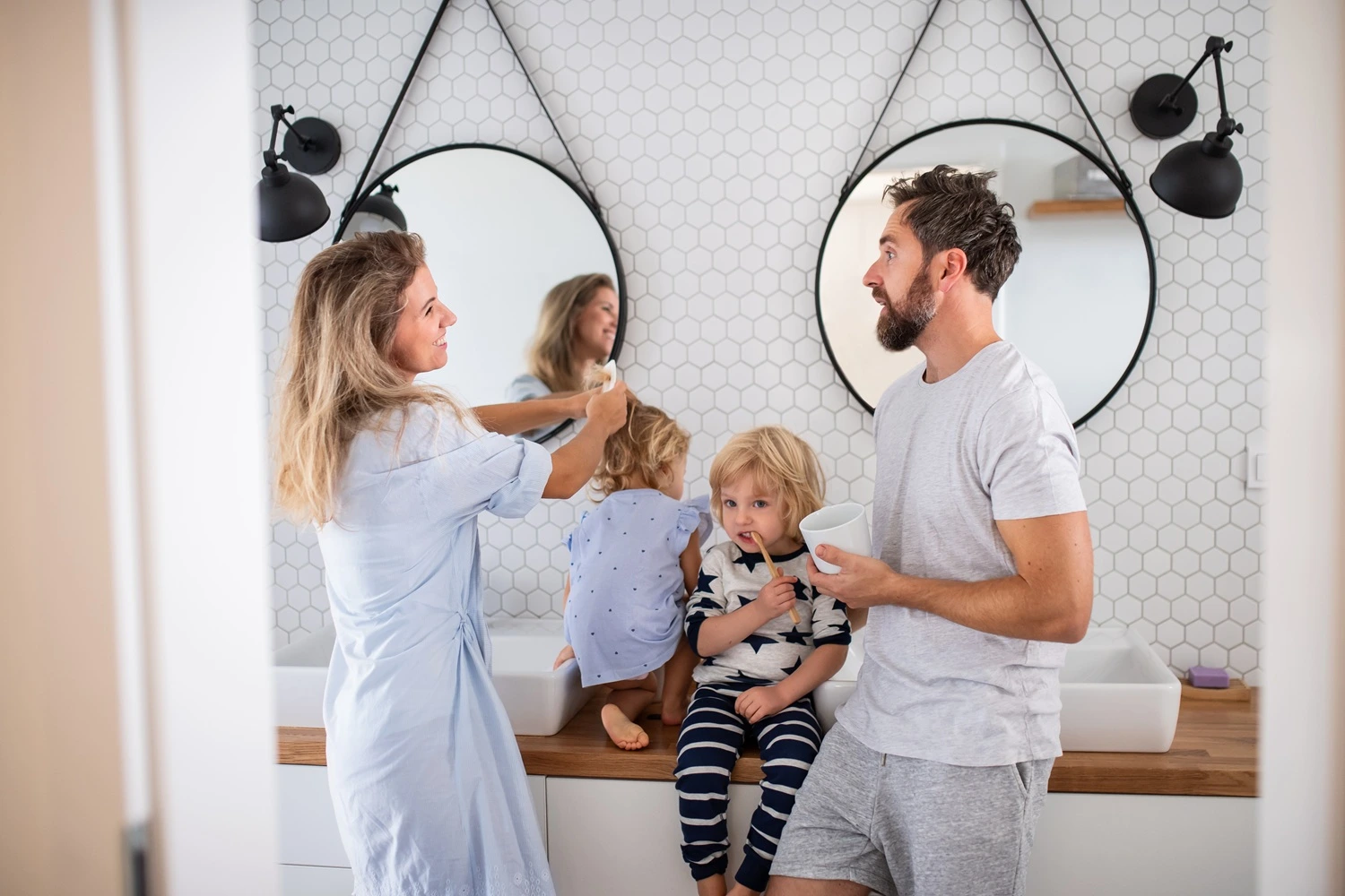 Family using a shared double vanity in a bright modern bathroom, showing how a well planned layout supports busy morning routines