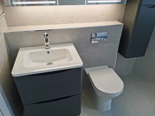 a bathroom with a mirror sink and toilet