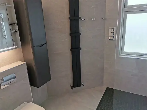 a bathroom with a shower and a black radiator