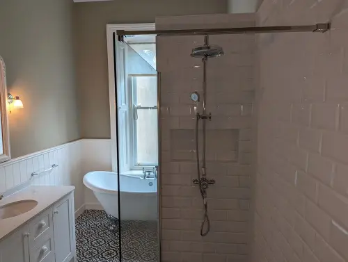 a bathroom with a shower and traditional tub