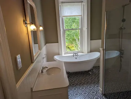 a bathroom with a tub sink and mirror