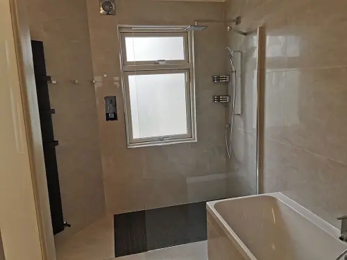 a bathroom with a window, shower and tub
