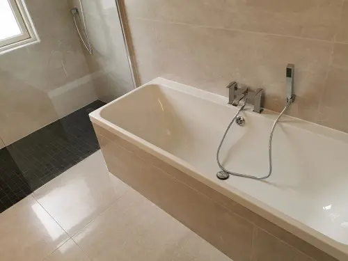 a bathtub with a shower and a shower door
