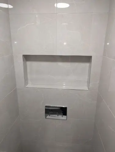 a white tile wc with a shelf