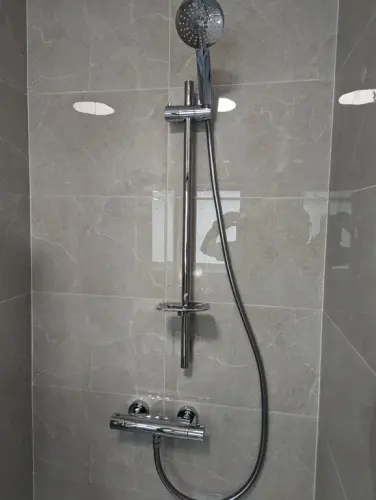a en suite shower with a hose